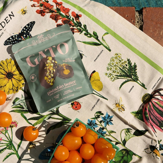 Gato product packaging with cherry tomatoes on a floral tablecloth