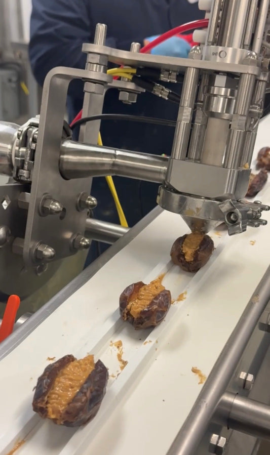 Medjool dates being filled with nut butter during Gato’s production process.