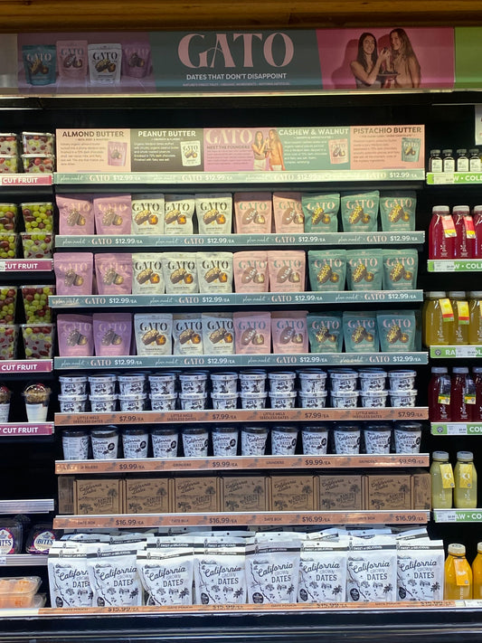 Gato chocolate-covered Medjool date pouches displayed in the refrigerated case at Plum Market.
