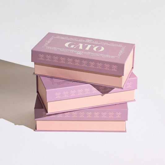 Stack of pink boxes with 'GATO' branding on a light background