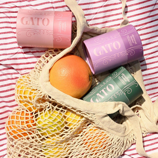 Mesh bag with Gato products and fruits on a red and white striped background